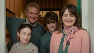 The Brown family stands smiling in their doorway in Paddington In Peru.