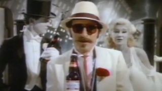 A guy in a white suit offers a Budweiser.