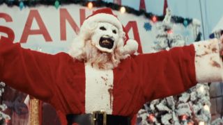 Art the Clown smiling in a bloody Santa outfit in Terrifier 3