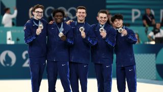 The 2024 US Men's Olympics Gymnastics team celebrate with their bronze medals.